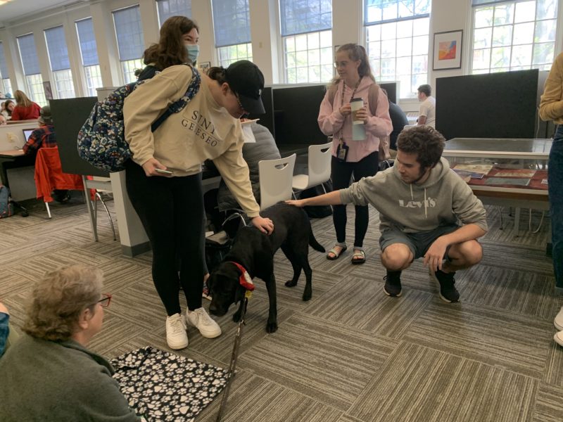 Students getting some furry friend therapy at Fraser Hall Library
